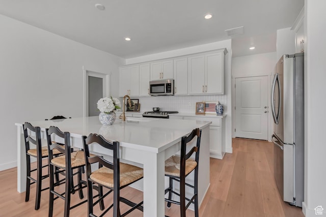 169 E Volunteer Dr, Spanish Fork, UT 84660 - kitchen with stainless steel appliances, light countertops, tasteful backsplash, light wood-style floors, and recessed lighting