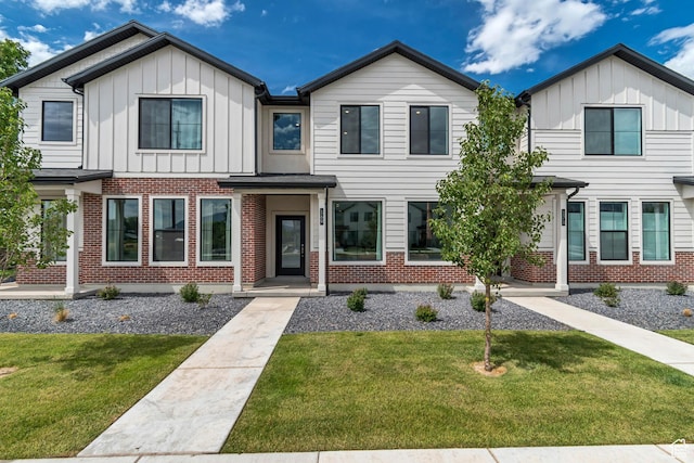 169 E Volunteer Dr, Spanish Fork, UT 84660 - view of front of house featuring board and batten siding, a front lawn, and brick siding