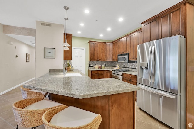 4988 S Timber Way E Unit 206, Millcreek, UT 84117 - kitchen featuring appliances with stainless steel finishes, a peninsula, light tile patterned floors, a kitchen breakfast bar, and tasteful backsplash