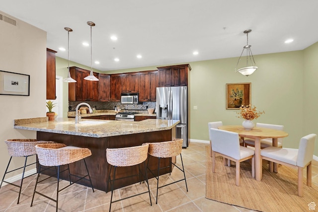 4988 S Timber Way E Unit 206, Millcreek, UT 84117 - kitchen with stainless steel appliances, a peninsula, light stone countertops, decorative backsplash, and a breakfast bar area