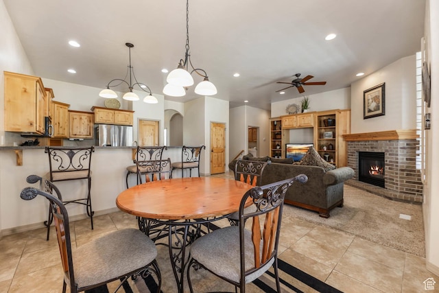1524 W Foliage Ln, South Jordan, UT 84095 - dining area featuring a ceiling fan, arched walkways, recessed lighting, a brick fireplace, and light tile patterned floors