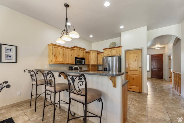 1524 W Foliage Ln, South Jordan, UT 84095 - kitchen with appliances with stainless steel finishes, arched walkways, a peninsula, a kitchen bar, and dark countertops