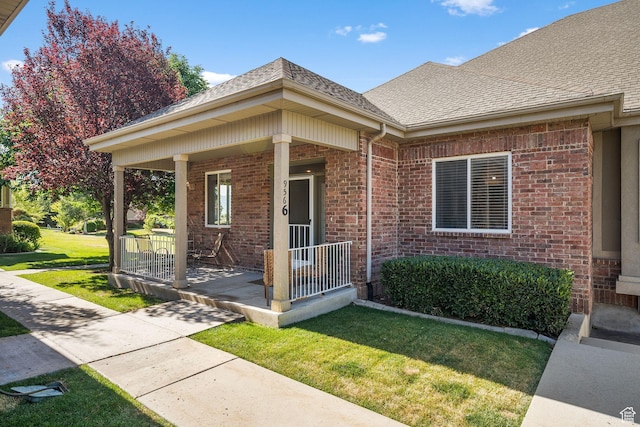 9566 N 4500 W, Cedar Hills, UT 84062 - view of exterior entry featuring a porch, brick siding, a yard, and roof with shingles