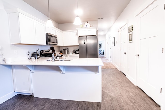 3722 W 1440 N Unit F202, Lehi, UT 84043 - kitchen featuring stainless steel appliances, a peninsula, wood finished floors, a breakfast bar area, and light countertops