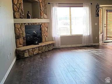3462 Heyward Ct, Eagle Mountain, UT 84043 - unfurnished living room featuring wood finished floors and a fireplace