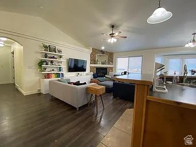 3462 Heyward Ct, Eagle Mountain, UT 84043 - living area featuring ceiling fan, lofted ceiling, arched walkways, dark wood-style floors, and plenty of natural light