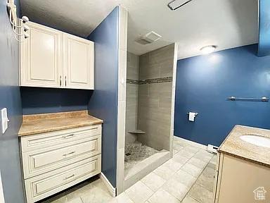3462 Heyward Ct, Eagle Mountain, UT 84043 - full bathroom with vanity, tiled shower, and tile patterned flooring