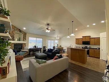 3462 Heyward Ct, Eagle Mountain, UT 84043 - living area with a ceiling fan, vaulted ceiling, a fireplace, dark wood-style flooring, and recessed lighting