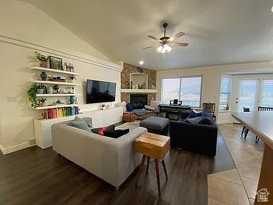3462 Heyward Ct, Eagle Mountain, UT 84043 - living area featuring lofted ceiling, ceiling fan, a fireplace, and dark wood-style flooring