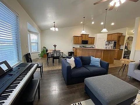 3462 Heyward Ct, Eagle Mountain, UT 84043 - living room featuring dark wood-style floors, a chandelier, ceiling fan, and vaulted ceiling