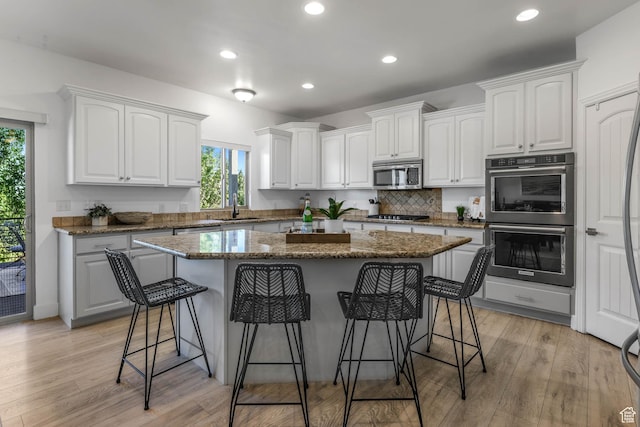 1692 N Sage Ln, Saratoga Springs, UT 84045 - kitchen featuring stainless steel appliances, plenty of natural light, a kitchen island, a breakfast bar, and recessed lighting