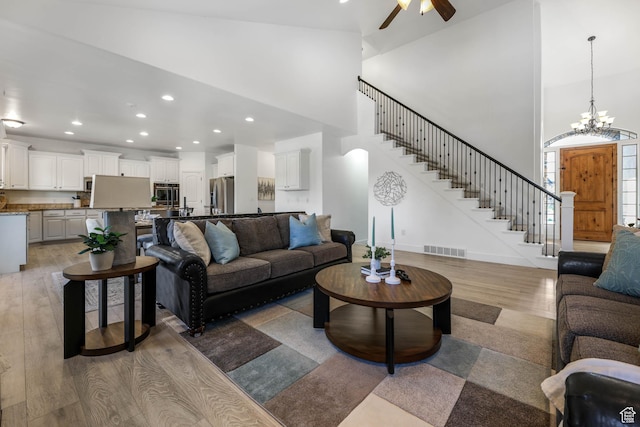 1692 N Sage Ln, Saratoga Springs, UT 84045 - living room featuring light wood-type flooring, a towering ceiling, stairway, ceiling fan, and recessed lighting