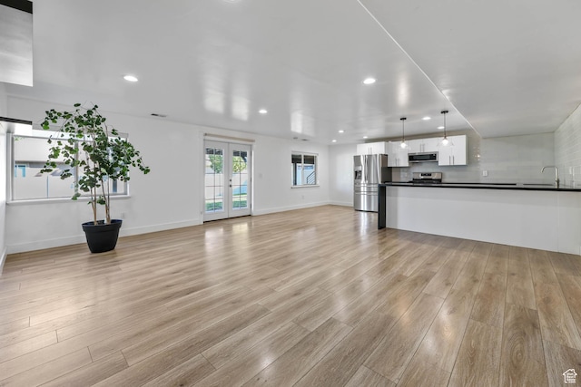 1692 N Sage Ln, Saratoga Springs, UT 84045 - unfurnished living room featuring light wood-style floors, recessed lighting, and french doors