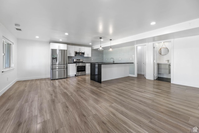 1692 N Sage Ln, Saratoga Springs, UT 84045 - kitchen with stainless steel appliances, dark countertops, open floor plan, white cabinets, and recessed lighting