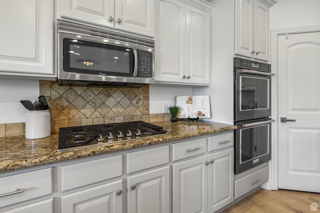 1692 N Sage Ln, Saratoga Springs, UT 84045 - kitchen with appliances with stainless steel finishes, white cabinets, backsplash, and dark stone countertops