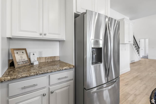 1692 N Sage Ln, Saratoga Springs, UT 84045 - kitchen with stainless steel refrigerator with ice dispenser, white cabinets, light wood-style flooring, and dark stone counters