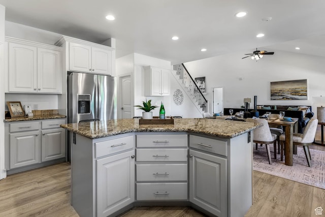 1692 N Sage Ln, Saratoga Springs, UT 84045 - kitchen with stainless steel fridge, a center island, ceiling fan, stone countertops, and white cabinets