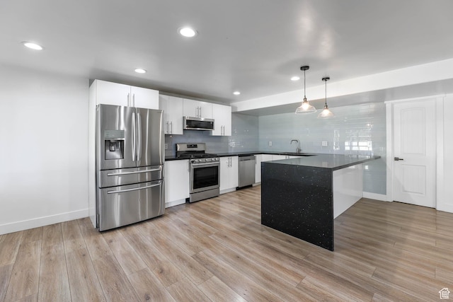 1692 N Sage Ln, Saratoga Springs, UT 84045 - kitchen featuring stainless steel appliances, dark countertops, a peninsula, white cabinetry, and recessed lighting