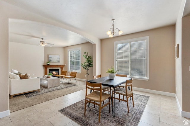 5549 W Parkway W Dr, Highland, UT 84003 - dining space featuring arched walkways, light tile patterned floors, a ceiling fan, a glass covered fireplace, and a chandelier