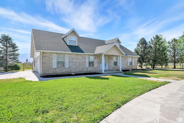 3112 N Pelican Dr, Farr West, UT 84404 - new england style home with a porch, a front yard, driveway, and a shingled roof