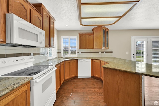 3112 N Pelican Dr, Farr West, UT 84404 - kitchen with white appliances, a peninsula, dark wood-type flooring, glass insert cabinets, and stone countertops