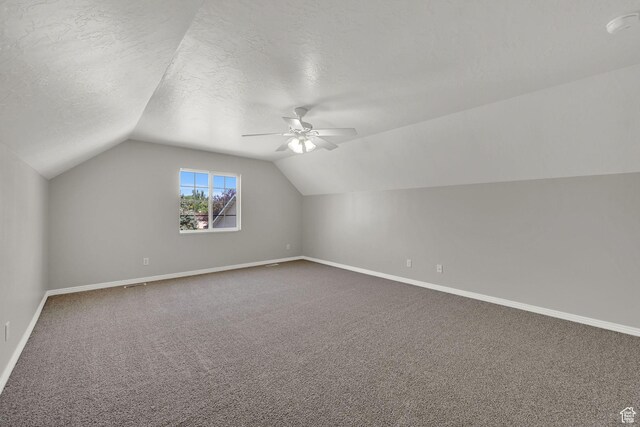 3112 N Pelican Dr, Farr West, UT 84404 - additional living space with lofted ceiling, dark carpet, ceiling fan, and a textured ceiling