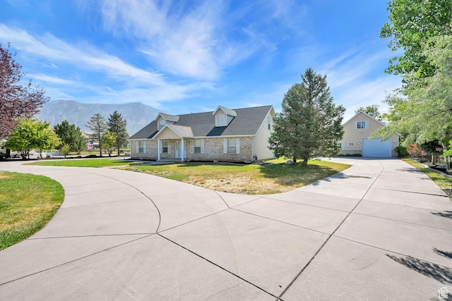 3112 N Pelican Dr, Farr West, UT 84404 - new england style home with driveway, a mountain view, a garage, a front lawn, and stone siding