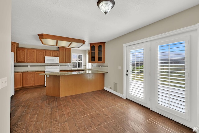 3112 N Pelican Dr, Farr West, UT 84404 - kitchen with white appliances, a peninsula, glass insert cabinets, tasteful backsplash, and a textured ceiling