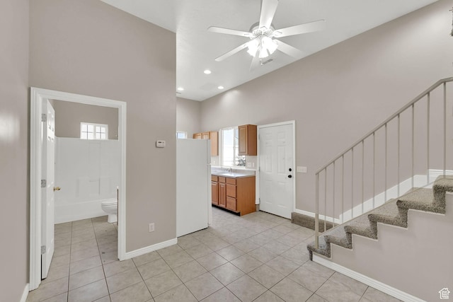 3112 N Pelican Dr, Farr West, UT 84404 - entryway featuring a ceiling fan, a high ceiling, stairway, plenty of natural light, and light tile patterned floors