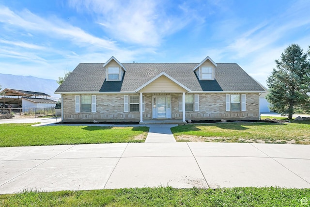 3112 N Pelican Dr, Farr West, UT 84404 - cape cod house featuring a front lawn, a porch, stone siding, and a mountain view