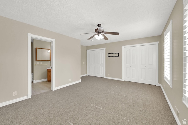 3112 N Pelican Dr, Farr West, UT 84404 - unfurnished bedroom with multiple closets, carpet flooring, a textured ceiling, connected bathroom, and a ceiling fan
