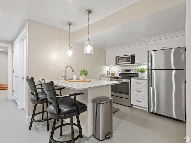2677 N 700 E, Provo, UT 84604 - kitchen featuring stainless steel appliances, a breakfast bar, white cabinetry, light stone counters, and light tile patterned flooring