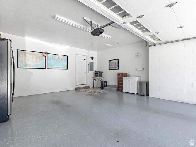 2677 N 700 E, Provo, UT 84604 - garage featuring freestanding refrigerator, electric panel, a garage door opener, and concrete block wall