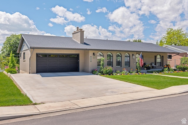 2677 N 700 E, Provo, UT 84604 - ranch-style house featuring an attached garage, a front lawn, driveway, a chimney, and covered porch