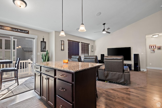 1769 W Valcrest Dr, Saratoga Springs, UT 84045 - kitchen featuring vaulted ceiling, wood finished floors, light stone counters, hanging light fixtures, and a kitchen island