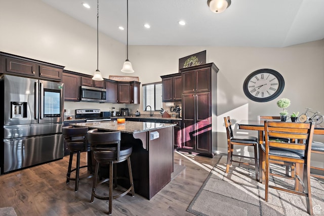 1769 W Valcrest Dr, Saratoga Springs, UT 84045 - kitchen with appliances with stainless steel finishes, high vaulted ceiling, a kitchen island, a kitchen bar, and dark brown cabinets