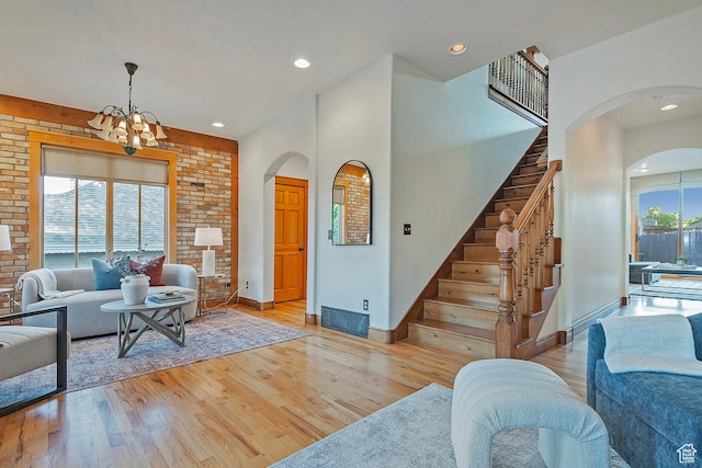 427 N J St E, Salt Lake City, UT 84103 - living area with arched walkways, a chandelier, light wood-style flooring, stairs, and recessed lighting
