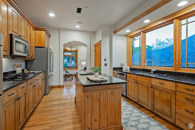 427 N J St E, Salt Lake City, UT 84103 - kitchen featuring appliances with stainless steel finishes, arched walkways, light wood finished floors, a center island, and recessed lighting