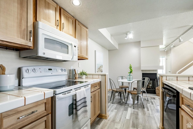 5441 S Spinnaker Row, Taylorsville, UT 84123 - kitchen featuring white appliances, tile countertops, light wood-style floors, rail lighting, and a textured ceiling