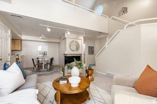 5441 S Spinnaker Row, Taylorsville, UT 84123 - living area featuring light carpet, rail lighting, a fireplace, and stairway