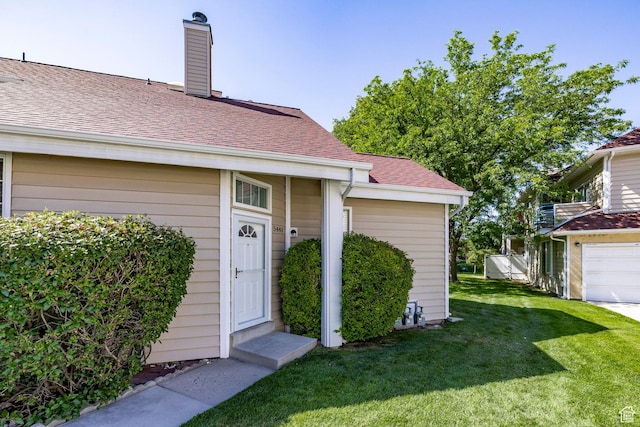 5441 S Spinnaker Row, Taylorsville, UT 84123 - property entrance featuring a yard, a chimney, roof with shingles, and a garage