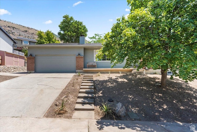 787 S 1680 E, Pleasant Grove, UT 84062 - view of front of house with an attached garage, concrete driveway, brick siding, a chimney, and a mountain view