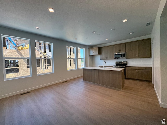 1456 N 1875 W Unit 147, Layton, UT 84041 - kitchen with stainless steel appliances, light wood-style flooring, recessed lighting, a center island with sink, and light countertops