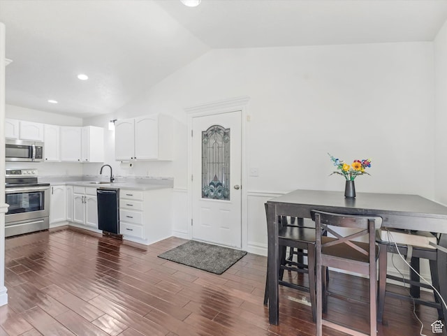 4049 E Dillons Dr N, Eagle Mountain, UT 84005 - kitchen featuring appliances with stainless steel finishes, vaulted ceiling, white cabinets, light countertops, and dark wood finished floors