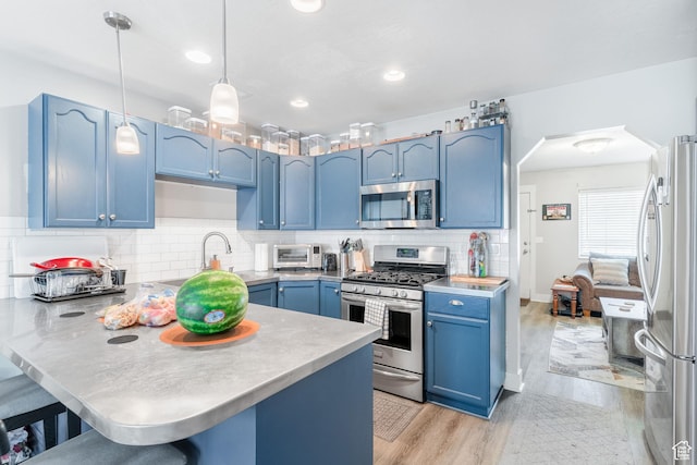 287 E 2300 N Unit 30, North Ogden, UT 84414 - kitchen featuring stainless steel appliances, blue cabinetry, arched walkways, a peninsula, and light wood-type flooring