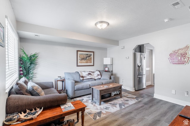287 E 2300 N Unit 30, North Ogden, UT 84414 - living area featuring arched walkways, wood finished floors, and a textured ceiling