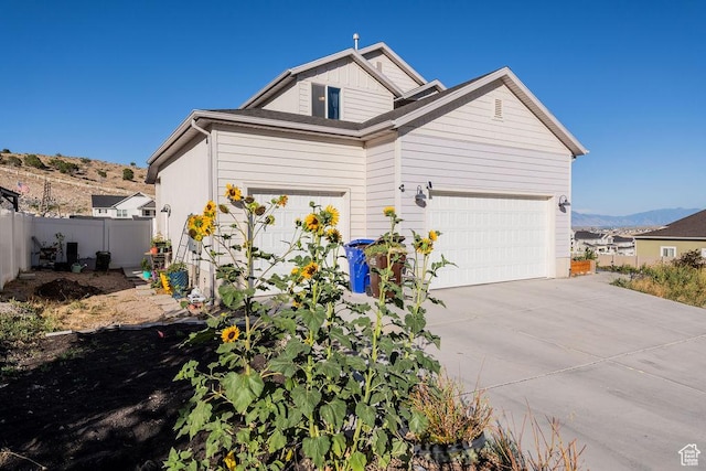7390 N Pawnee Rd, Eagle Mountain, UT 84005 - view of home's exterior with driveway, a garage, and a mountain view