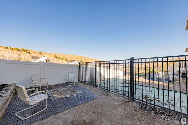 7390 N Pawnee Rd, Eagle Mountain, UT 84005 - fenced backyard with a covered pool and a patio area