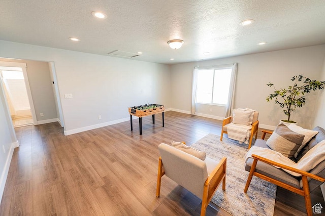 7390 N Pawnee Rd, Eagle Mountain, UT 84005 - living area with light wood-style floors, a textured ceiling, and recessed lighting