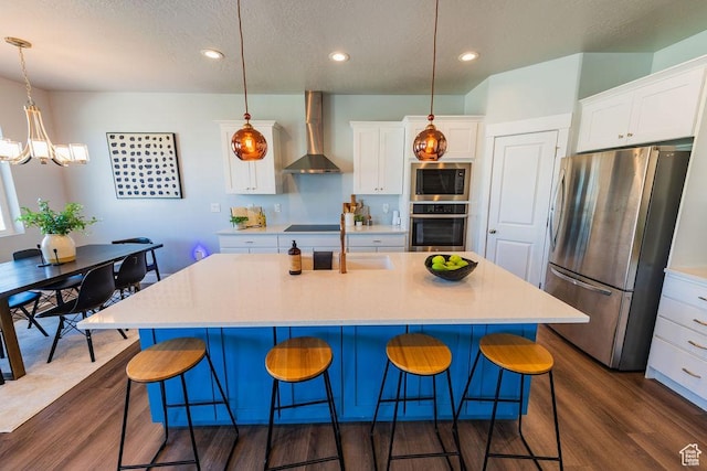 7390 N Pawnee Rd, Eagle Mountain, UT 84005 - kitchen with stainless steel appliances, wall chimney range hood, dark wood-type flooring, light countertops, and recessed lighting